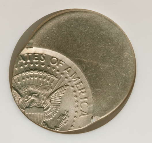 2014 Kennedy half dollar off-center strike error showing displaced design and blank planchet crescent